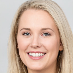 Joyful white young-adult female with long  brown hair and blue eyes