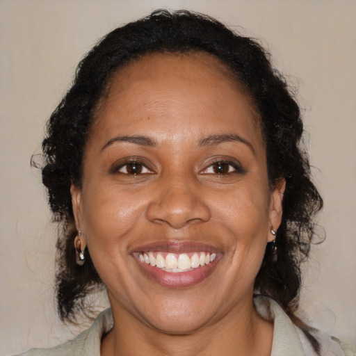 Joyful black adult female with medium  brown hair and brown eyes