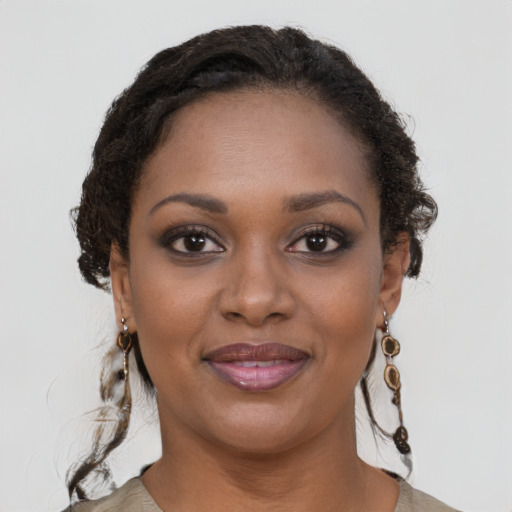 Joyful black young-adult female with long  brown hair and brown eyes