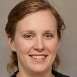 Joyful white adult female with medium  brown hair and blue eyes