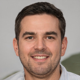 Joyful white adult male with short  brown hair and brown eyes