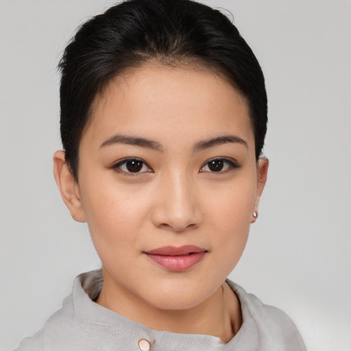 Joyful asian young-adult female with short  brown hair and brown eyes