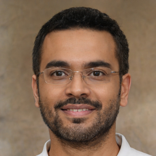 Joyful latino young-adult male with short  black hair and brown eyes