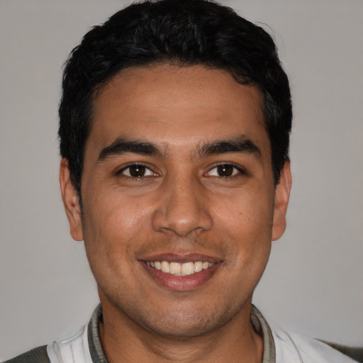 Joyful white young-adult male with short  black hair and brown eyes