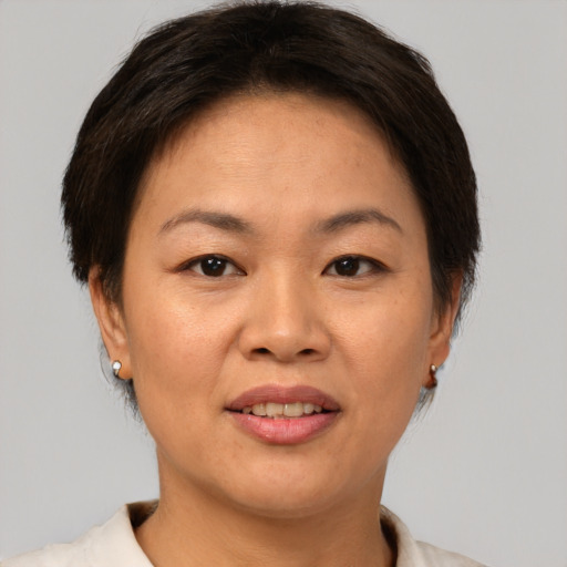 Joyful asian adult female with short  brown hair and brown eyes