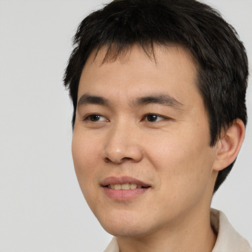 Joyful asian young-adult male with short  black hair and brown eyes