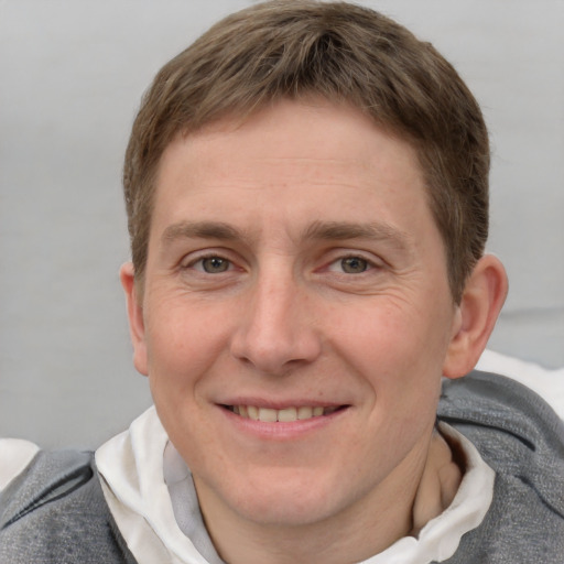 Joyful white adult male with short  brown hair and grey eyes