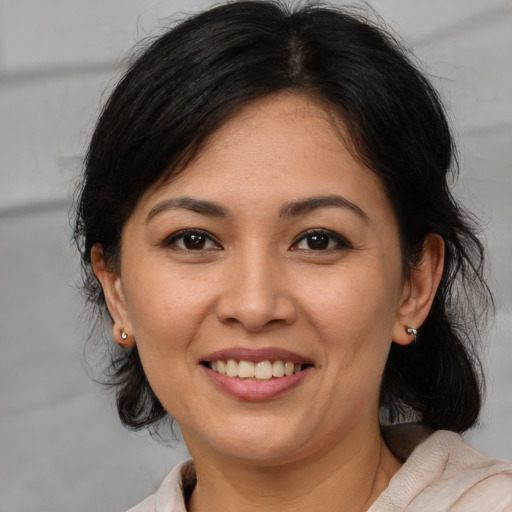 Joyful latino adult female with medium  brown hair and brown eyes