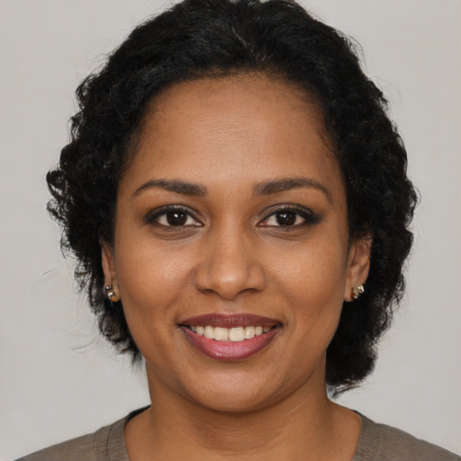 Joyful black young-adult female with short  brown hair and brown eyes