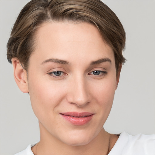 Joyful white young-adult female with short  brown hair and grey eyes