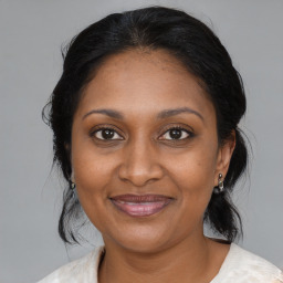 Joyful black adult female with medium  brown hair and brown eyes