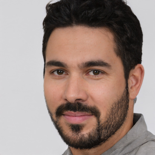 Joyful white young-adult male with short  black hair and brown eyes