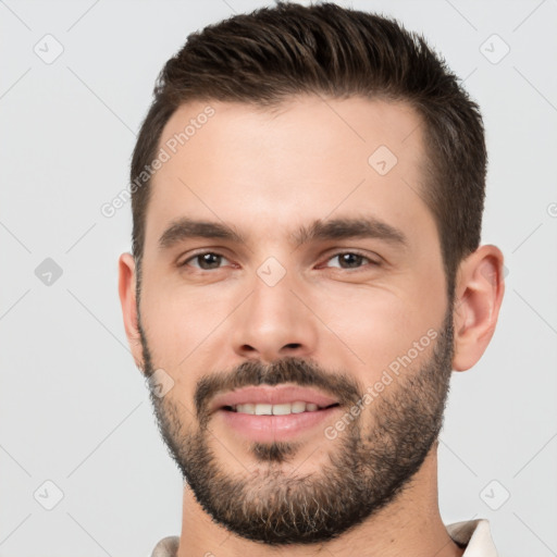 Joyful white young-adult male with short  black hair and brown eyes