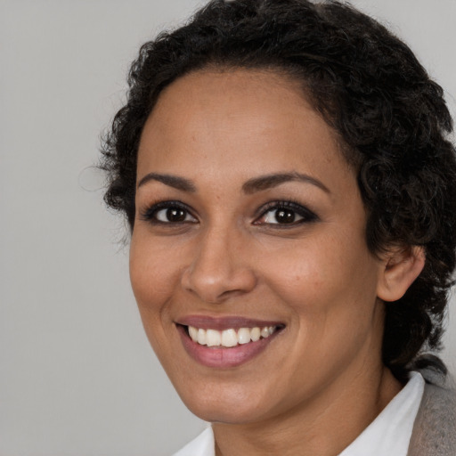 Joyful latino adult female with medium  brown hair and brown eyes