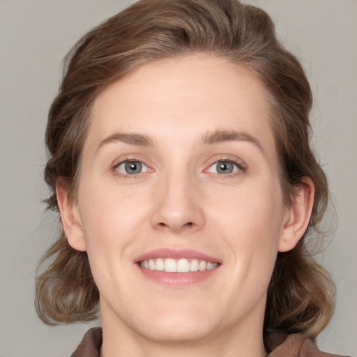 Joyful white young-adult female with medium  brown hair and blue eyes