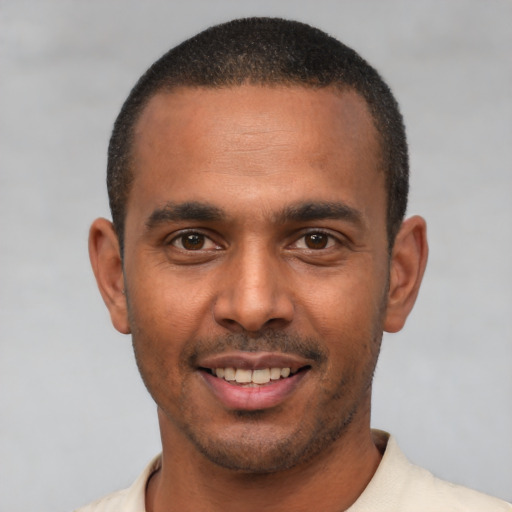 Joyful latino young-adult male with short  brown hair and brown eyes