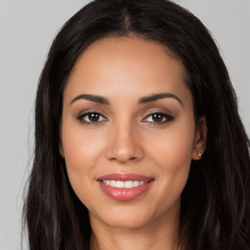 Joyful latino young-adult female with long  brown hair and brown eyes