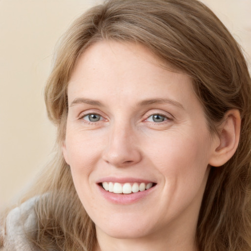 Joyful white young-adult female with long  brown hair and blue eyes