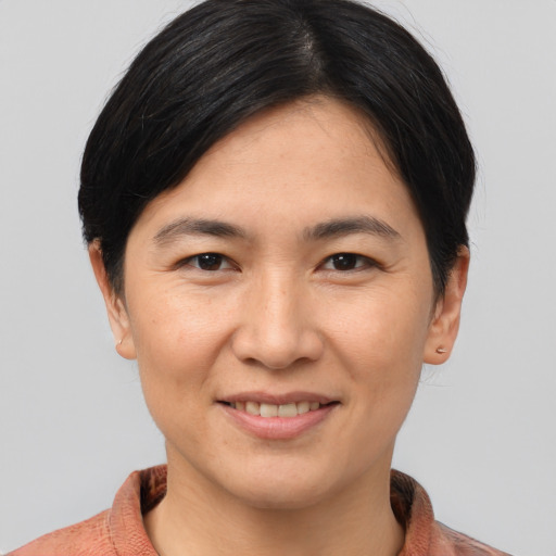 Joyful asian young-adult female with short  brown hair and brown eyes