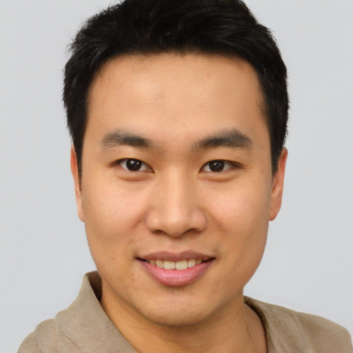 Joyful asian young-adult male with short  brown hair and brown eyes