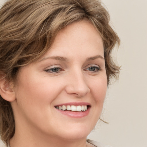 Joyful white young-adult female with medium  brown hair and green eyes