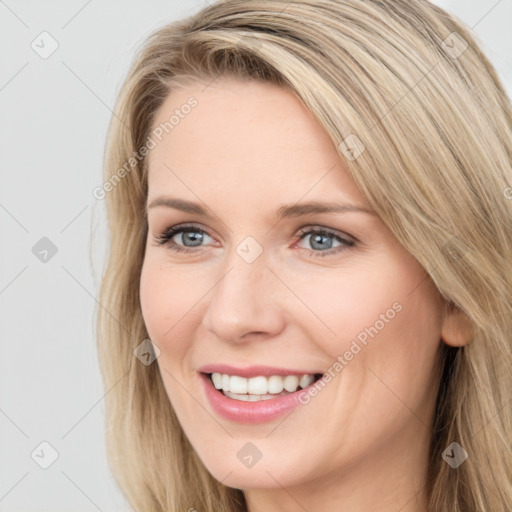 Joyful white young-adult female with long  brown hair and blue eyes