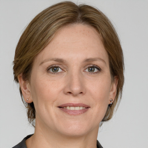 Joyful white adult female with medium  brown hair and grey eyes