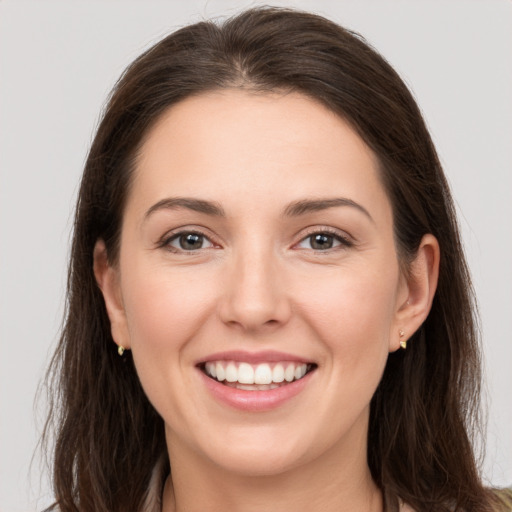 Joyful white young-adult female with long  brown hair and grey eyes