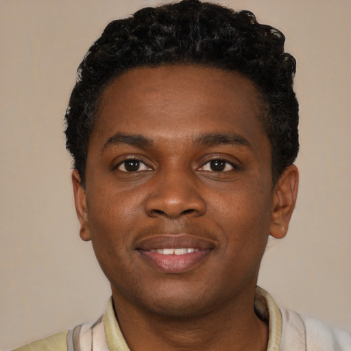 Joyful black young-adult male with short  brown hair and brown eyes