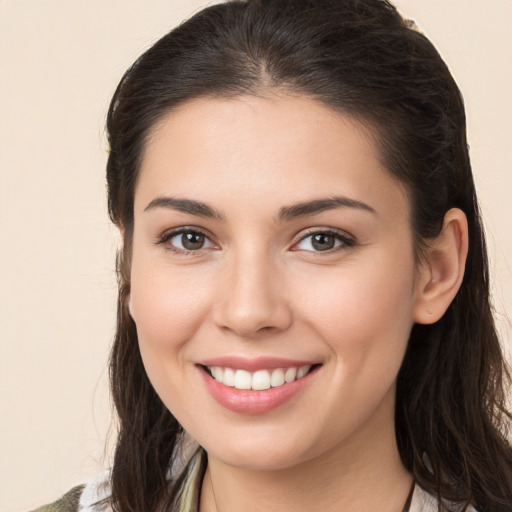 Joyful white young-adult female with long  brown hair and brown eyes