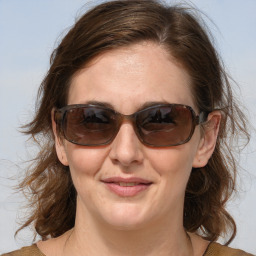 Joyful white adult female with medium  brown hair and blue eyes