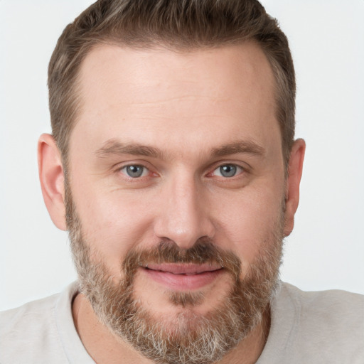 Joyful white young-adult male with short  brown hair and grey eyes