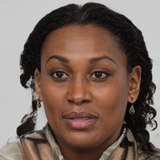 Joyful black adult female with long  brown hair and brown eyes