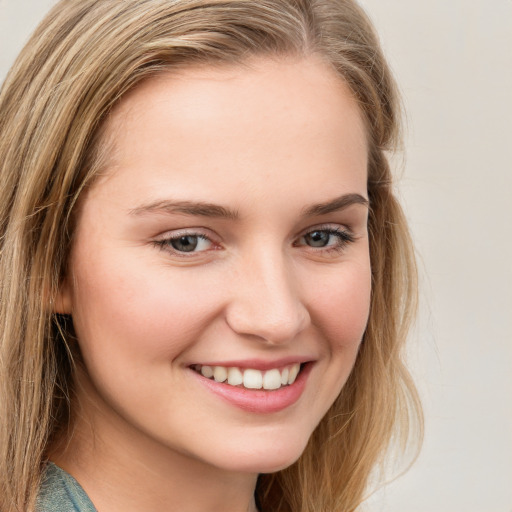 Joyful white young-adult female with long  brown hair and blue eyes