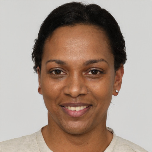 Joyful black young-adult female with short  black hair and brown eyes