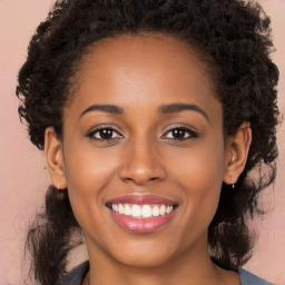 Joyful black young-adult female with long  brown hair and brown eyes