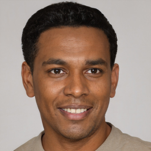 Joyful black young-adult male with short  black hair and brown eyes
