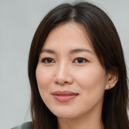 Joyful asian young-adult female with long  brown hair and brown eyes