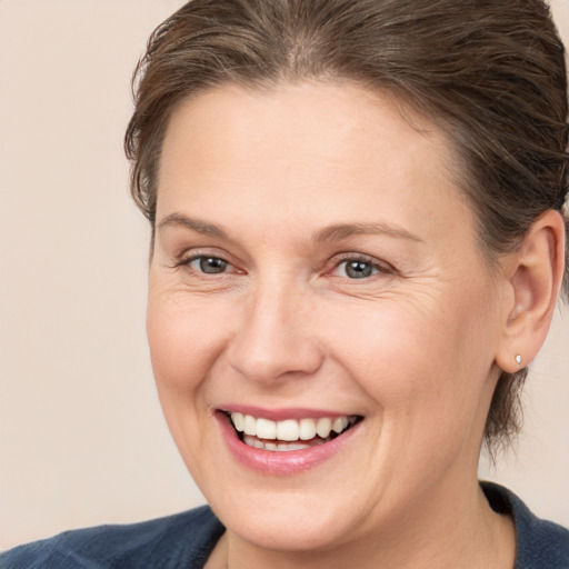 Joyful white adult female with medium  brown hair and brown eyes