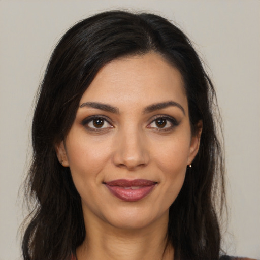 Joyful latino young-adult female with long  brown hair and brown eyes