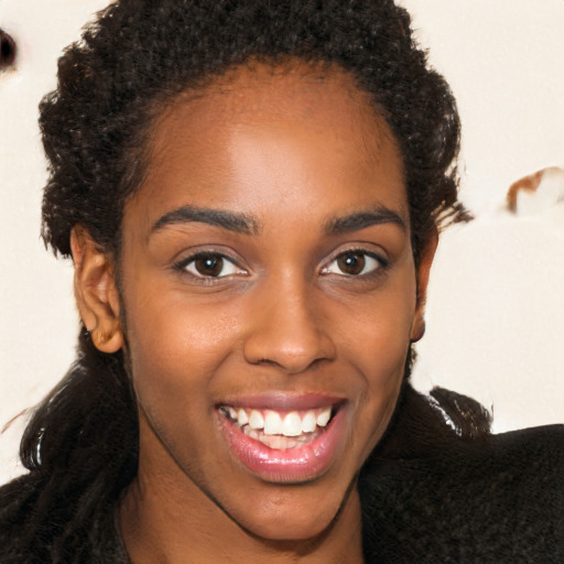 Joyful black young-adult female with long  brown hair and brown eyes