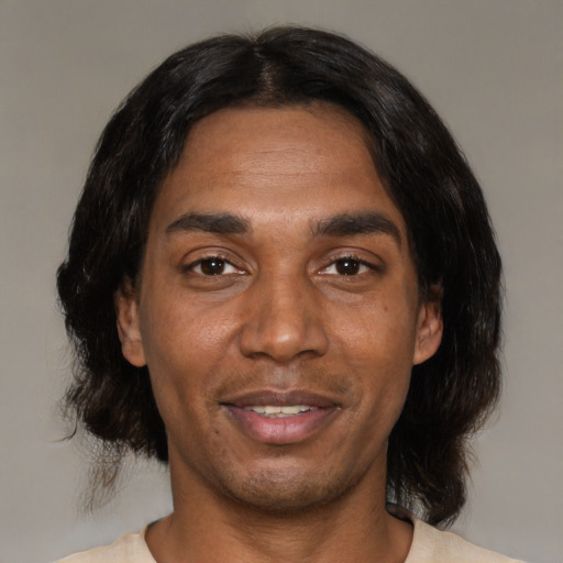 Joyful black young-adult male with medium  black hair and brown eyes