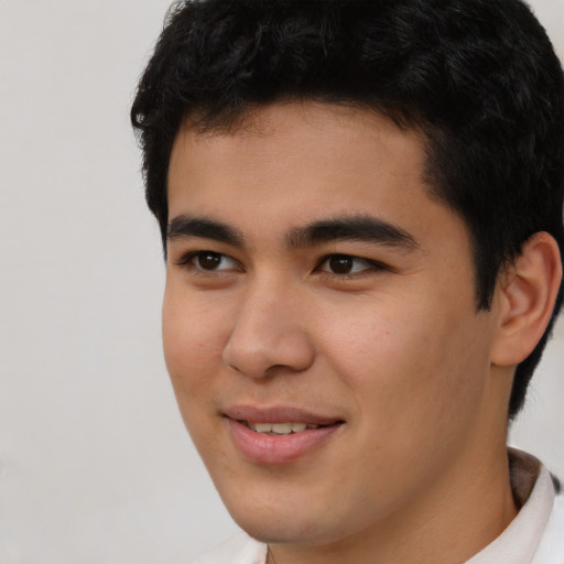 Joyful latino young-adult male with short  brown hair and brown eyes