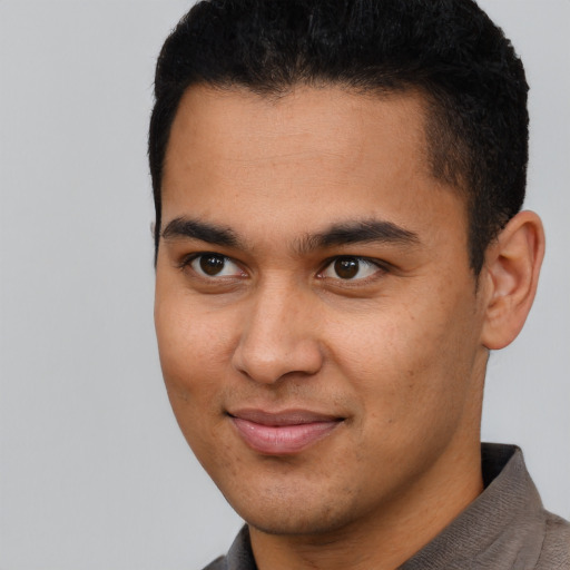 Joyful latino young-adult male with short  brown hair and brown eyes