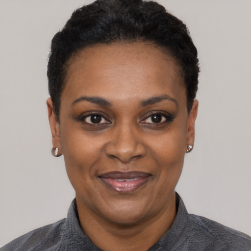Joyful black adult female with short  black hair and brown eyes
