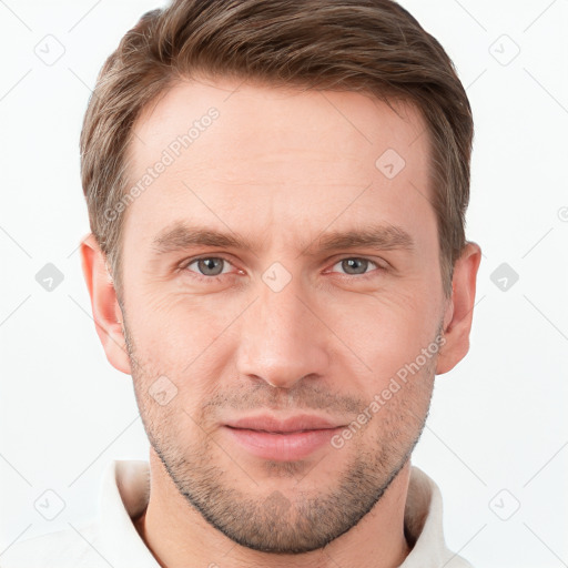 Joyful white young-adult male with short  brown hair and grey eyes