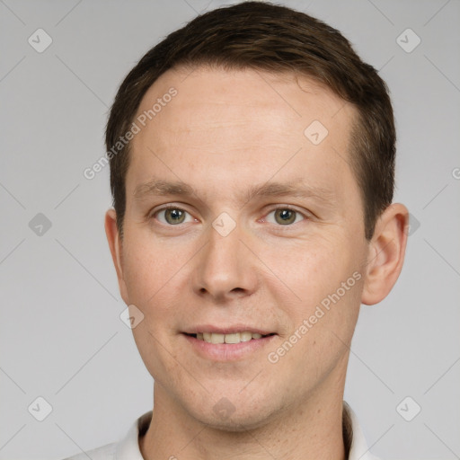 Joyful white young-adult male with short  brown hair and grey eyes