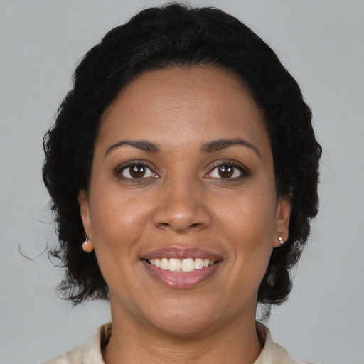 Joyful black adult female with medium  black hair and brown eyes