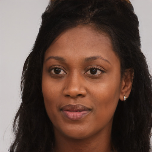 Joyful black young-adult female with long  brown hair and brown eyes