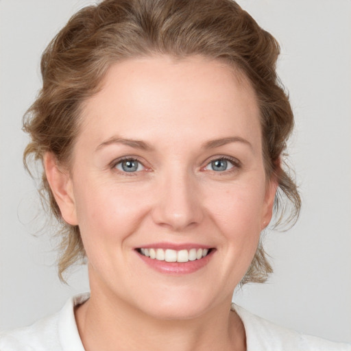 Joyful white young-adult female with medium  brown hair and blue eyes